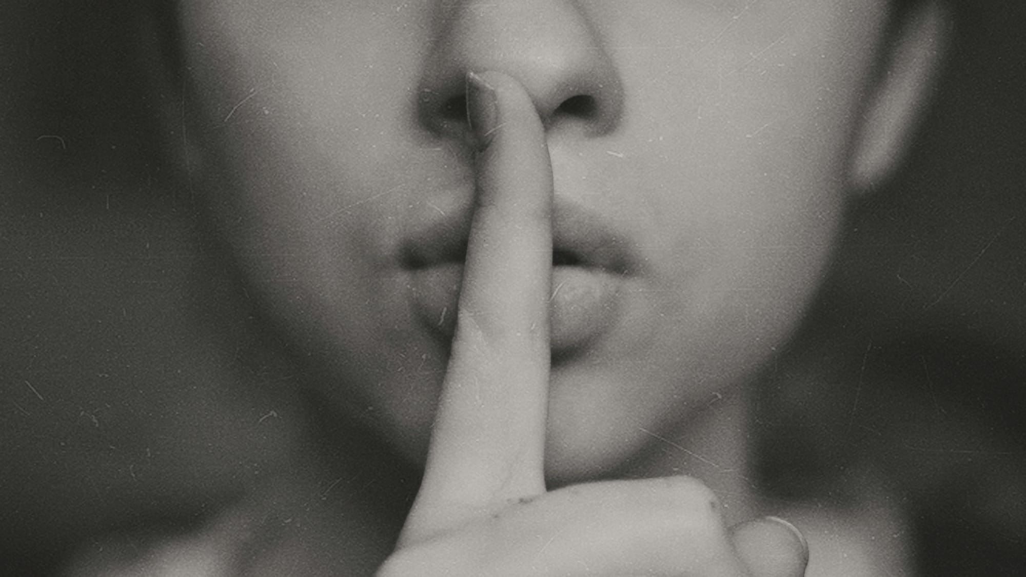 grayscale photo of woman doing silent hand sign